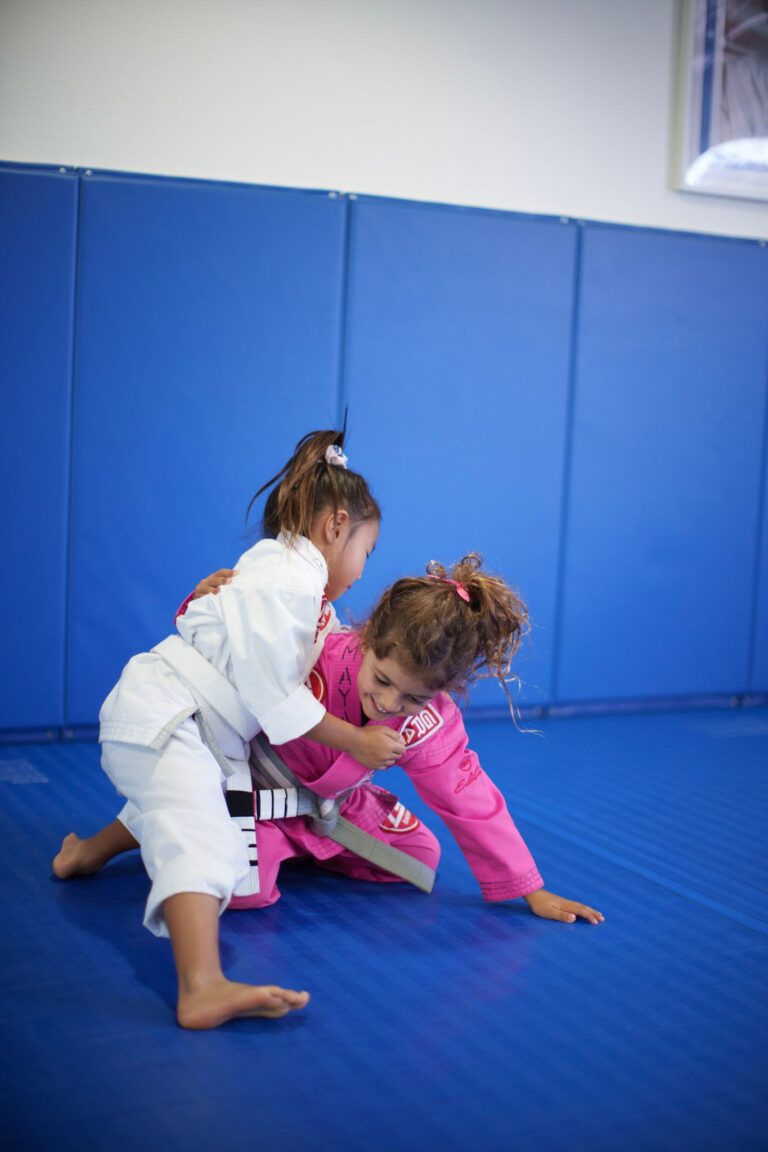 Young girls practicing a Jiu-Jitsu technique on the mats